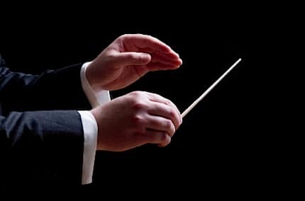 a conductors hands in the middle of a concert