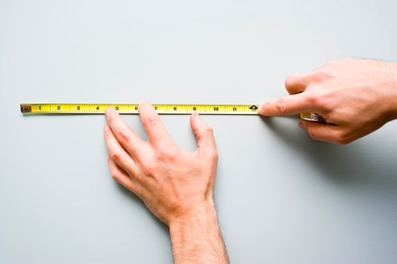 Men's Hands Holding a Measuring Tape Against a Wall - Photo courtesy of ©iStockphoto.com/michellegibson, Image #14720530